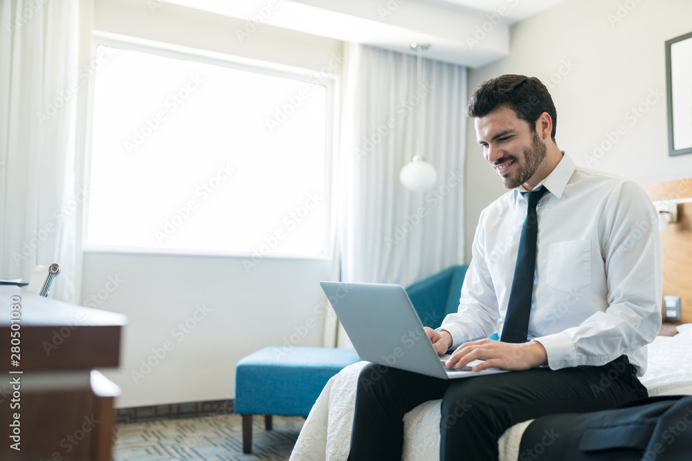 Confident Businessman Using Laptop In Room At Hotel Confident Businessman Using Laptop In Room At Hotel