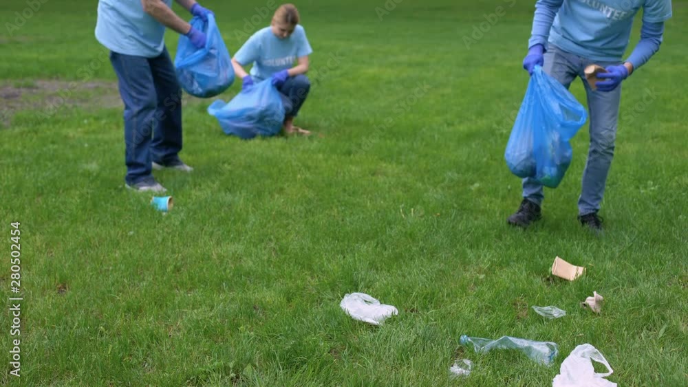 Volunteers collecting garbage in park, healthy ecosystem, resource conservation Volunteers collecting garbage in park, healthy ecosystem, resource conservation
