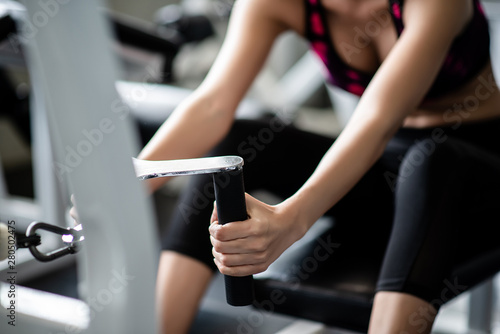 Young healthy woman working out with cable in the gym