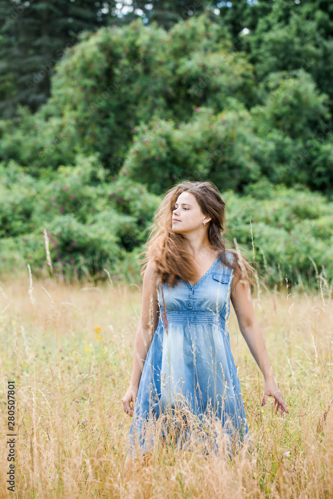 girl with long hair walks across the field girl with long hair walks across the field