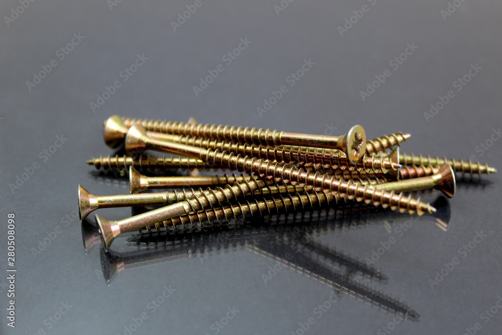 Iron long screws lie in one pile on a black background Iron long screws lie in one pile on a black background