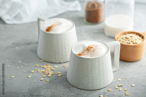 Oat milk latte with thick foam in ceramic mugs topped with cinnamon photo