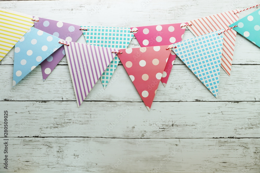 Obraz premium Colorful Bunting hanging with space copy on wooden background