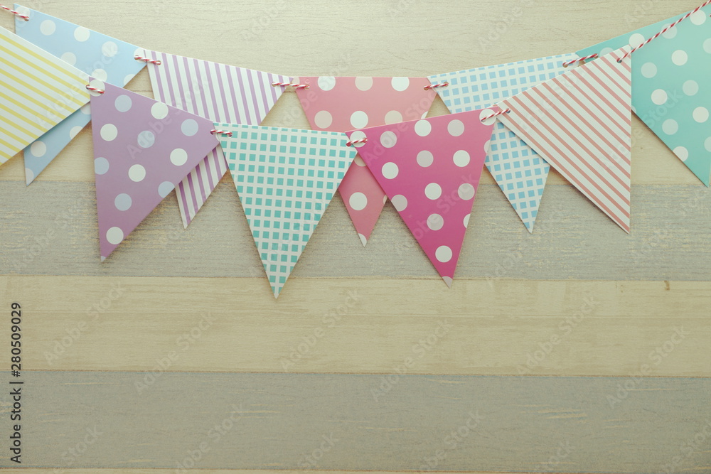 Obraz premium Colorful Bunting hanging with space copy on wooden background