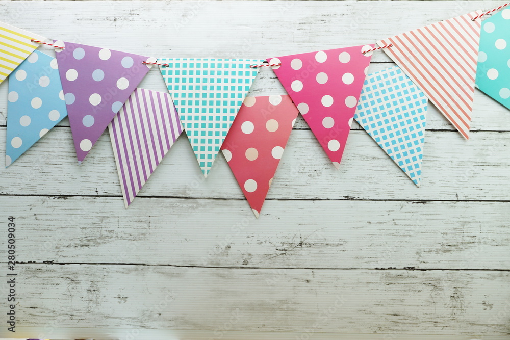 Obraz premium Colorful Bunting hanging with space copy on wooden background