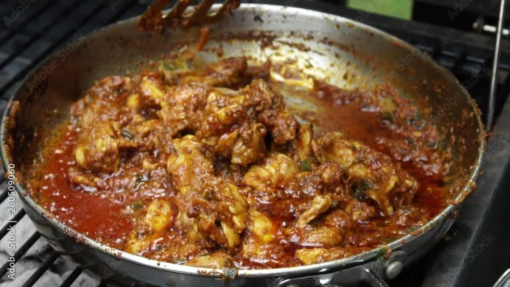 Cooking Tava chicken or skillet Chicken , an appetizer outdoors in a pan on coal Cooking Tava chicken or skillet Chicken , an appetizer outdoors in a pan on coal