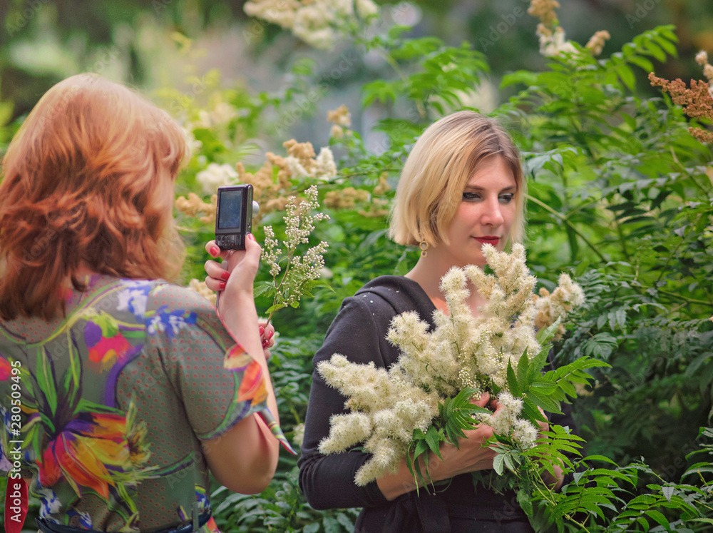 young girls take pictures of each other in the park young girls take pictures of each other in the park