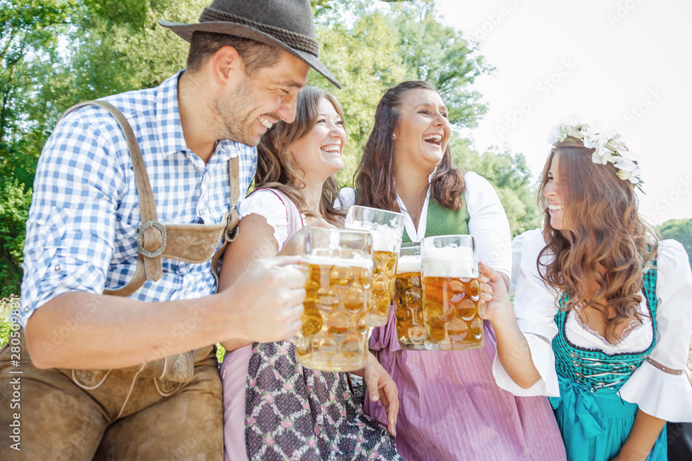 Five friends, men and women, having fun on Bavarian RIver and clinking glasses with beer Five friends, men and women, having fun on Bavarian RIver and clinking glasses with beer