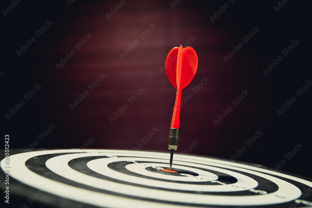Red dart arrow hitting the target center on vintage style bullseye for Business focus concept. Red dart arrow hitting the target center on vintage style bullseye for Business focus concept.
