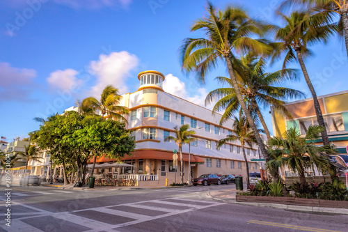 Obraz na plátne Ocean Drive scene at sunset with palm trees and cars passing by, Miami beach