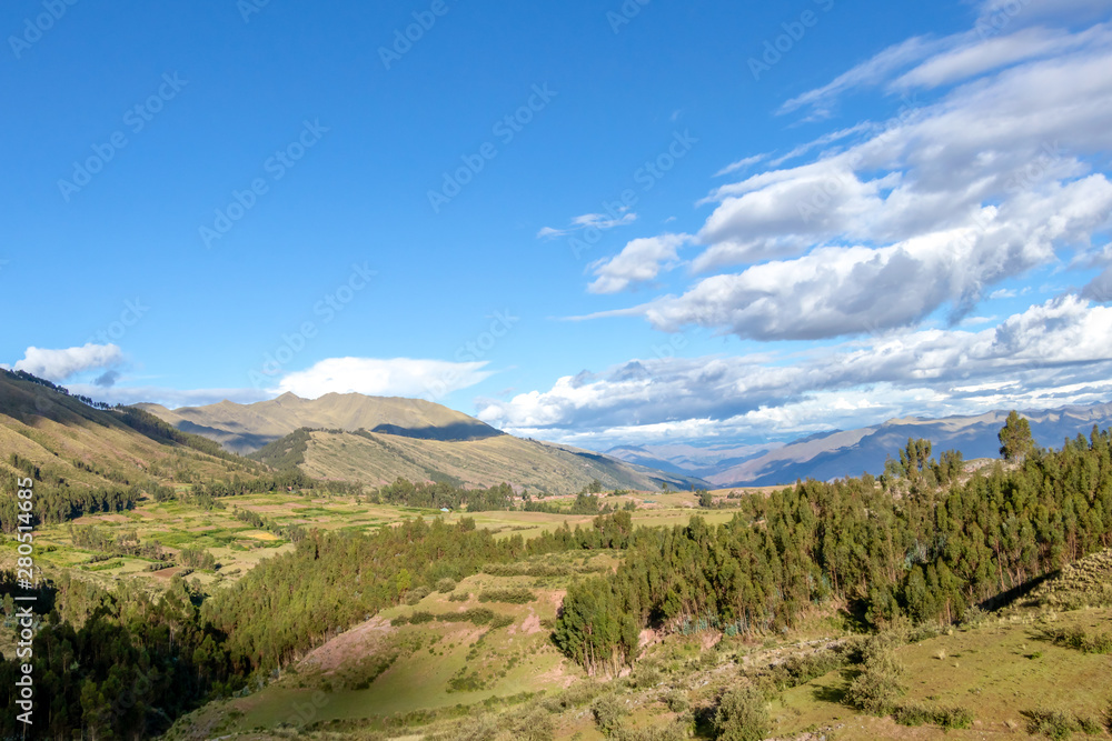 Mountain landscape with fertile valley below steep forests and ancient agricultural terraces at sunset