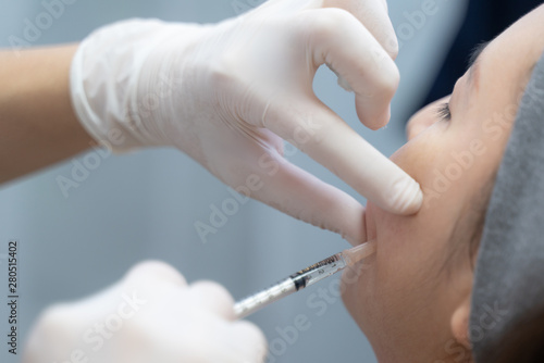 Needle mesotherapy in beauty clinic. Cosmetics injected to woman's face..