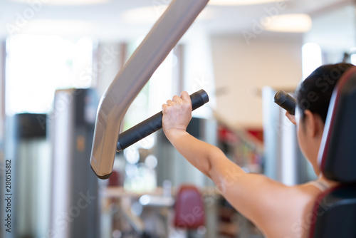 Women at the gym exercising on a machine.