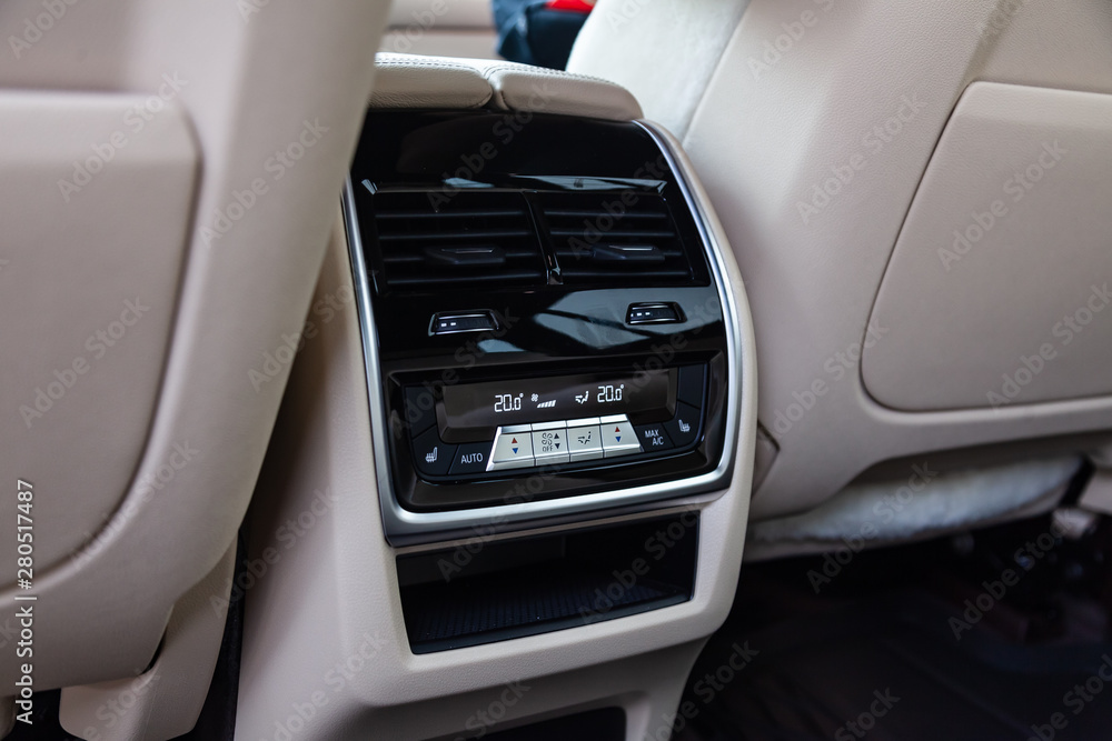 View to the white and brown interior of car with dashboard, rear ventilation duct and climate-control panel after cleaning before sale on parking