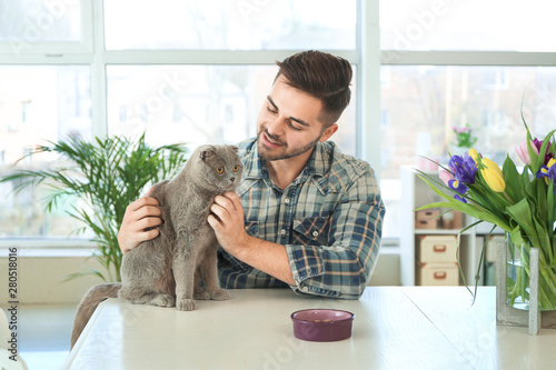 Young man feeding cute funn...