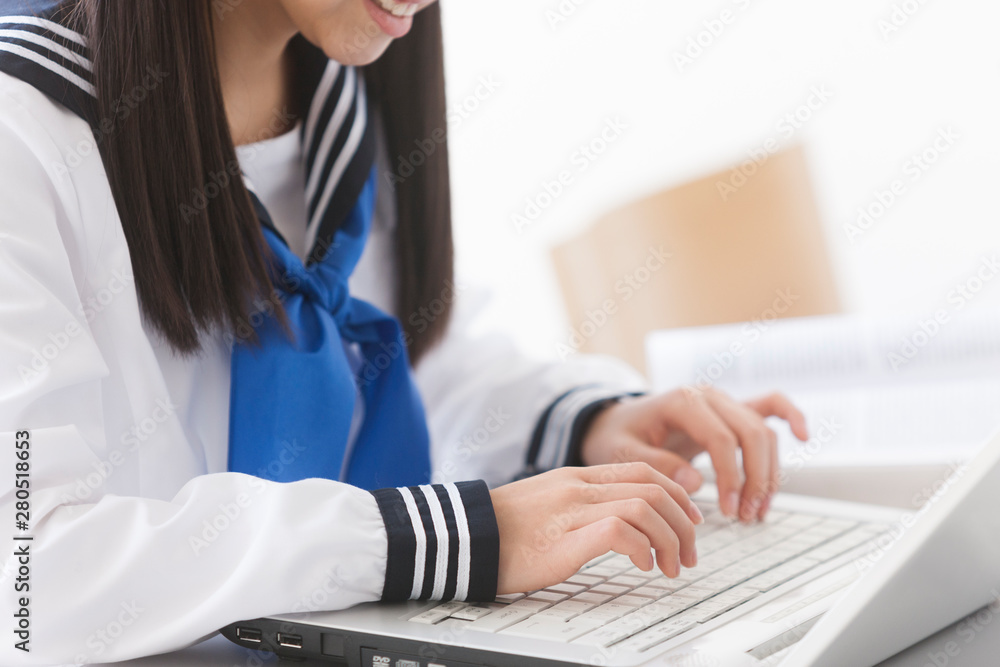 ノートパソコンを操作する女子校生 ノートパソコンを操作する女子校生