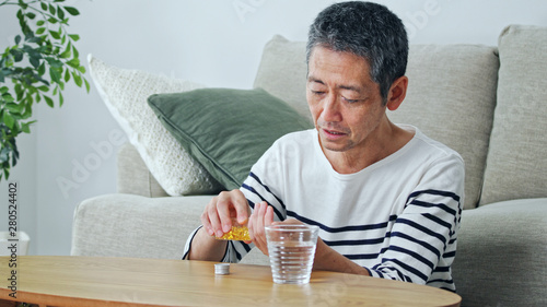 サプリメントを飲む男性 photo