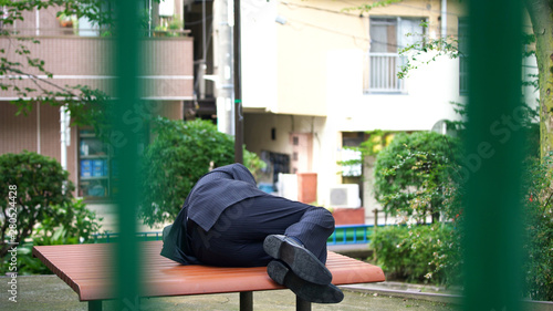 Fotografija ベンチで寝る男性