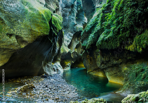 Vivid green river flowing through an underground gorge photo
