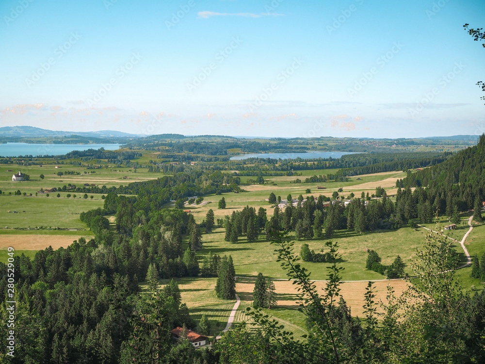 Panorama of Bavaria, Schwangau, near the Neuschwanstein castle. Smooth green meadows, lakes, forests