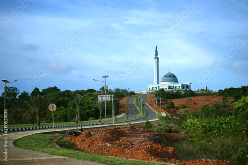 long road to beautiful mosque in glorius sky.  The biggest mosque in Tanjung Pinang, Riau Islands                                photo