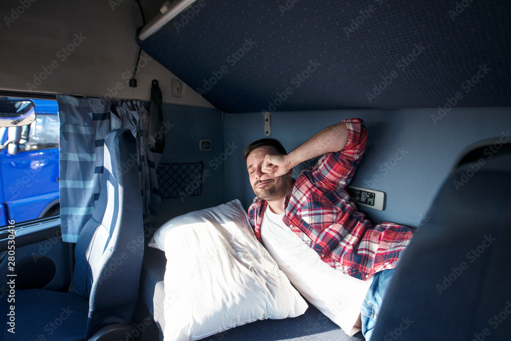 Truck cabin interior with driver sleeping in bed. Truck driver waking