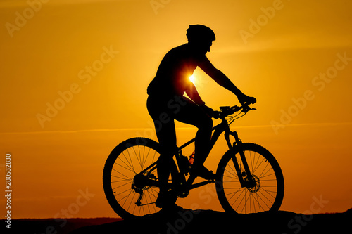 Silhouette of a sporty cyclist in helmet on a bike. Active Lifestyle Concept.