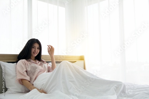 Portait of smiling lady wake up welcome morning light on the bed