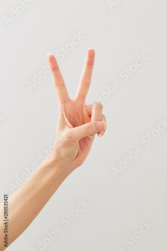 Woman hand showing peace two on white