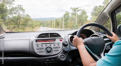 Travel by car, hands of driver on steering wheel