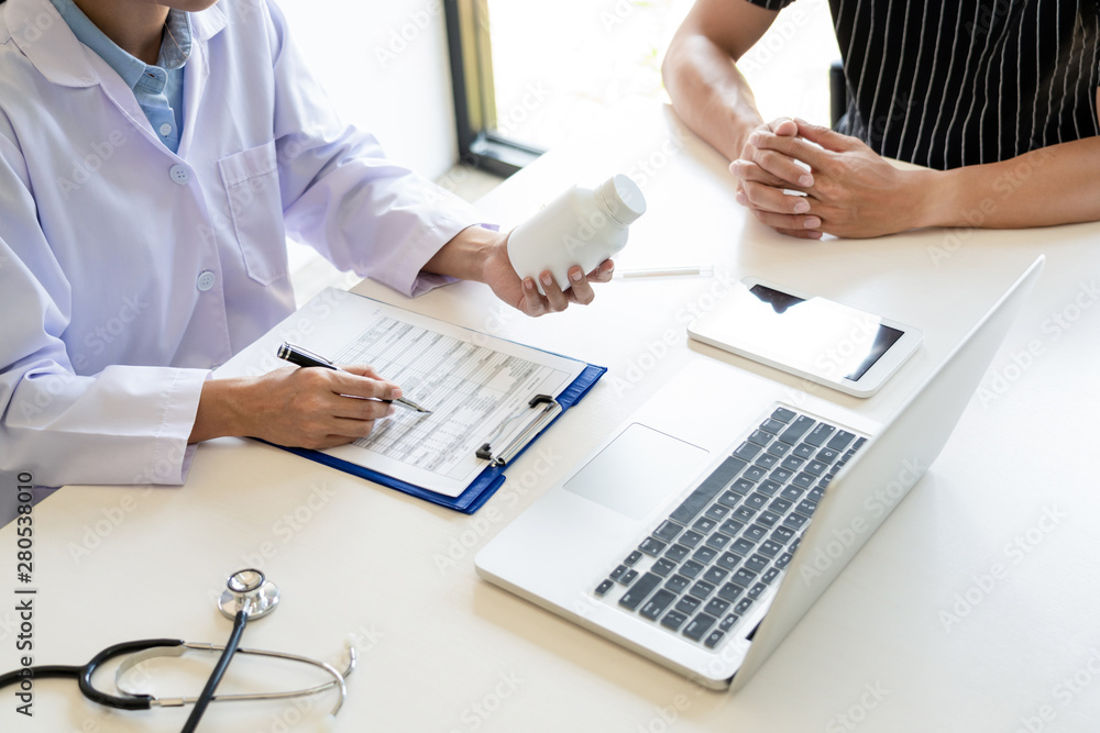 health care concept, doctor give a medicine bottle of drugs pills and explain the direction to use to patient in the hospital health care concept, doctor give a medicine bottle of drugs pills and explain the direction to use to patient in the hospital