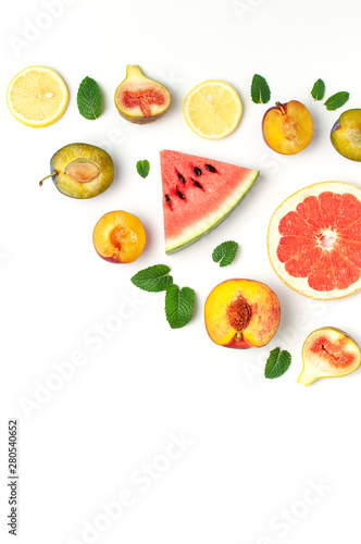 Fototapeta Naklejka Na Ścianę i Meble -  Tropical Summer Fruit Concept. Creative layout made of fresh ripe watermelon, peach, plum, fig, lemon, grapefruit and mint leaves on white background. Flat lay, top view, copy space. Food background