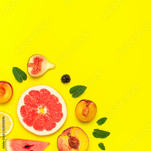 Tropical Summer Fruit Concept. Creative layout made of fresh ripe watermelon  peach  plum  fig  lemon  grapefruit and mint leaves on yellow background. Flat lay  top view  copy space. Food background