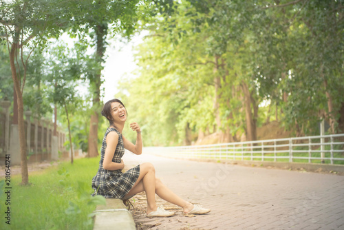 Free Download Happy asian woman in casual dress with big smile sit by walking street in public park and copy space,lifestyle teenange new generation. - GFXLoad