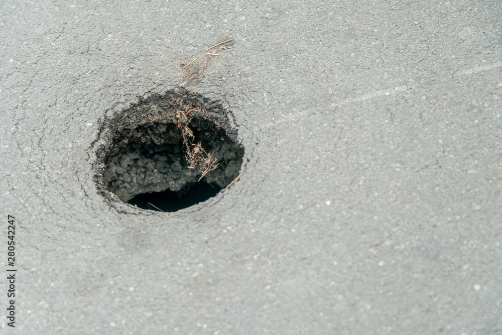 Round hole in asphalt, copy space Round hole in asphalt, copy space
