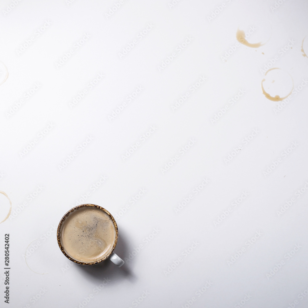 Simple gray background with a cup of coffee and prints from cups Simple gray background with a cup of coffee and prints from cups