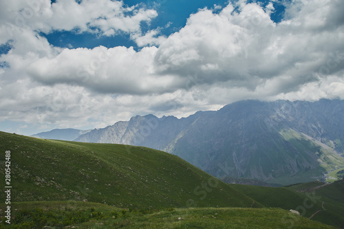 Large scenery of big empty green hill and cloudy sky. Kazbegi Georgia
