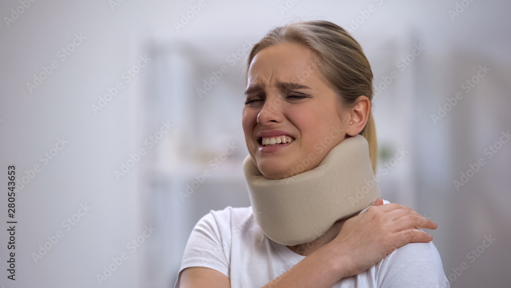 Upset girl in foam cervical collar suffering pain in shoulder, accident injury Upset girl in foam cervical collar suffering pain in shoulder, accident injury