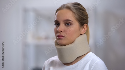Woman in foam cervical collar, health insurance, accident victim, medical clinic