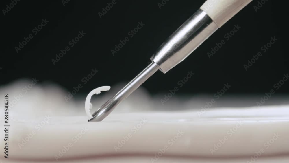 Artist uses a ribbon tool on a piece of plasticine macro shot