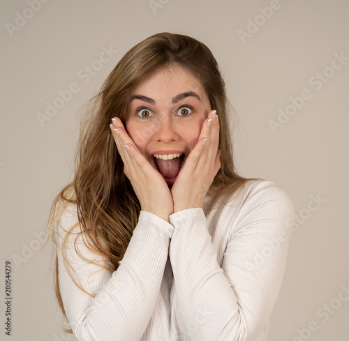 Happy young attractive teenager girl shocked with surprised funny face. Human expressions