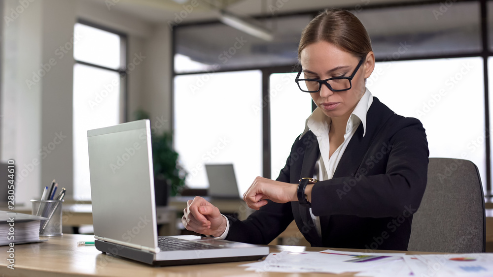 Busy woman looking at watch, confused by failing urgent task, missing deadline Busy woman looking at watch, confused by failing urgent task, missing deadline