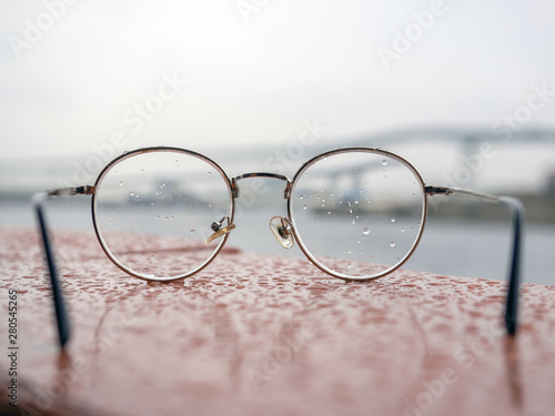 close up retro style eyeglasses all covered with water drops on lens.