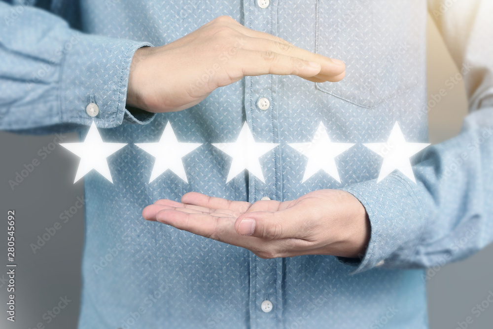 Hand touching five star symbol to increase rating Hand touching five star symbol to increase rating