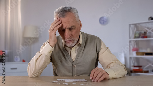 Pensioner trying to combine puzzle, having memory problems, cognitive impairment photo