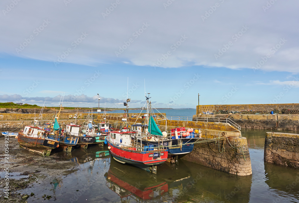 The Inner Harbour entrance at Slade Harbour, a small Fishing Village in County Wexford, Southern Ireland, with Fishing Boats lying on the Silt.