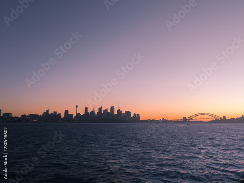 Silhouetted view of Sydney Harbour skyline at sunset, Australia