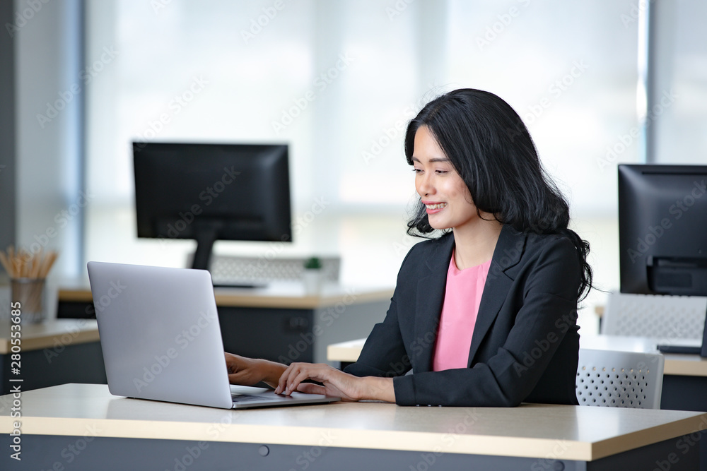 Asian businesswoman using laptop in office.. Asian businesswoman using laptop in office..