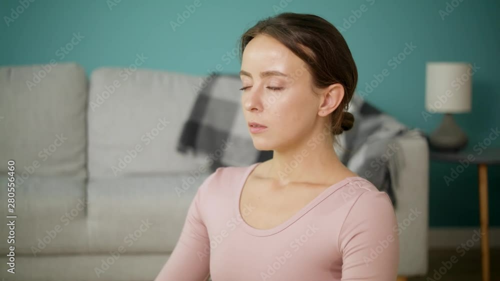 Woman meditates after practicing yoga in her living room. Woman meditates after practicing yoga in her living room.