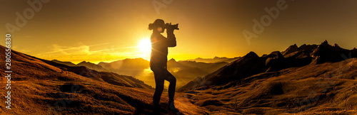 Fotografin bei Sonnenaufgang in den Bergen